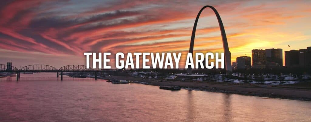 A scenic view of the Gateway Arch at sunset over the river.