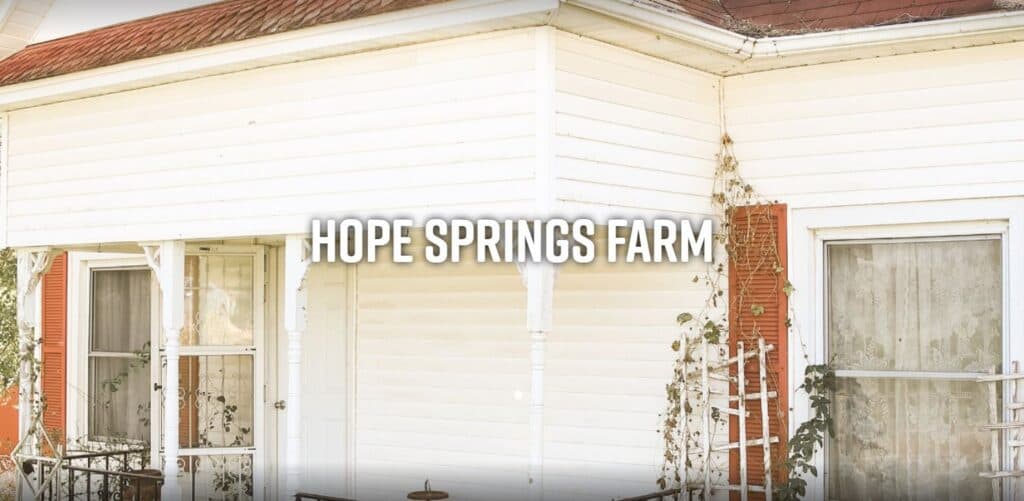 A white farmhouse with the text "Hope Springs Farm" prominently displayed.